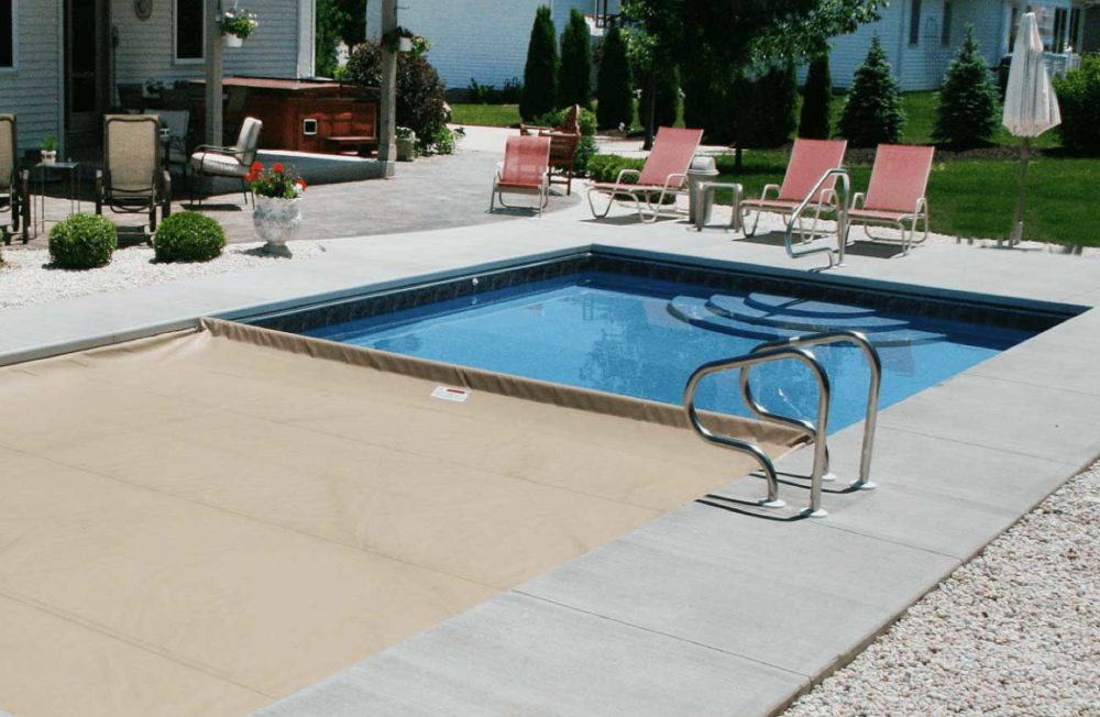 Rectangle Minnesota pool with paver patio surrounding the pool and automatic cover