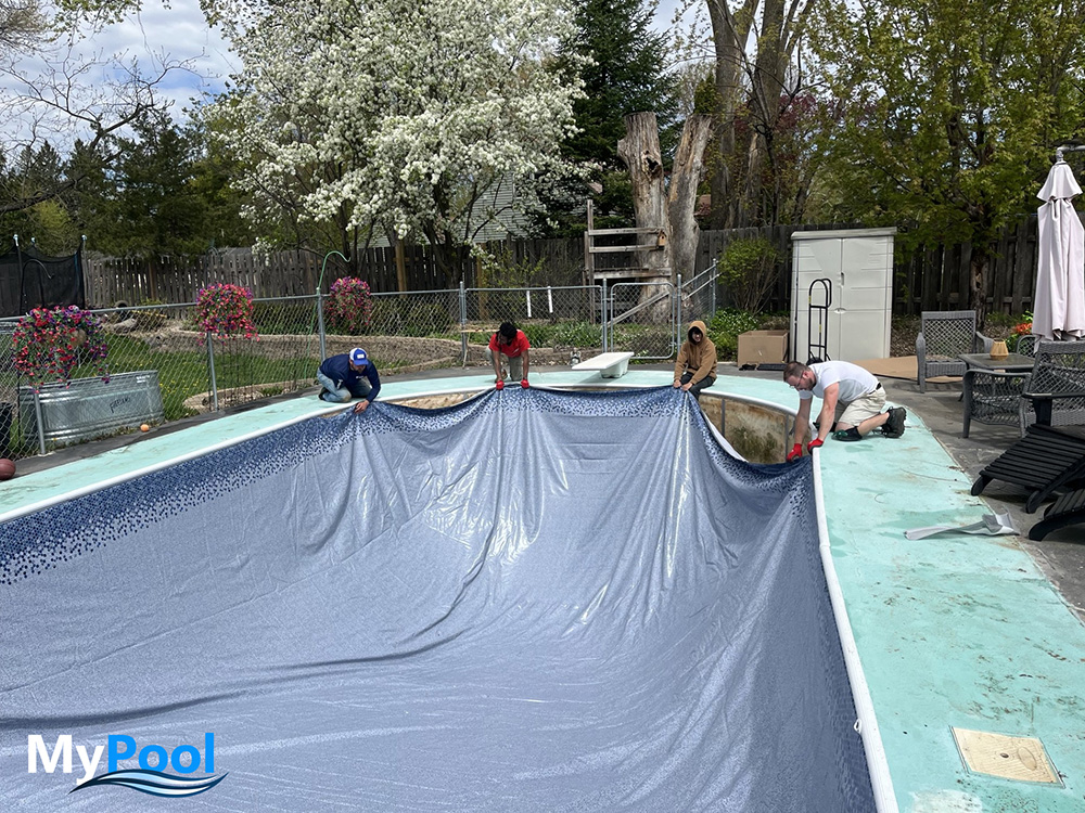 New vinyl pool liner being set into a Minnesota backyard pool